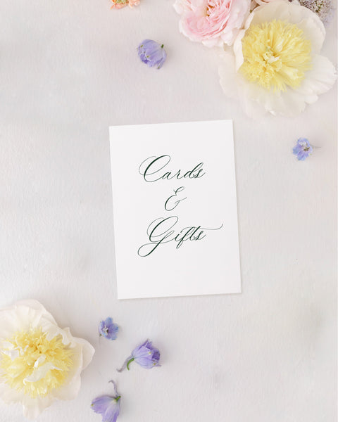 White card with 'Cards & Gifts' text surrounded by pastel flowers on a light background